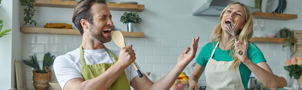 Young white couple laughing and playing in the kitchen, cooking Young white couple laughing and playing in the kitchen, cooking